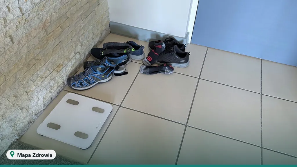 Waga łazienkowa i buty sportowe na podłodze