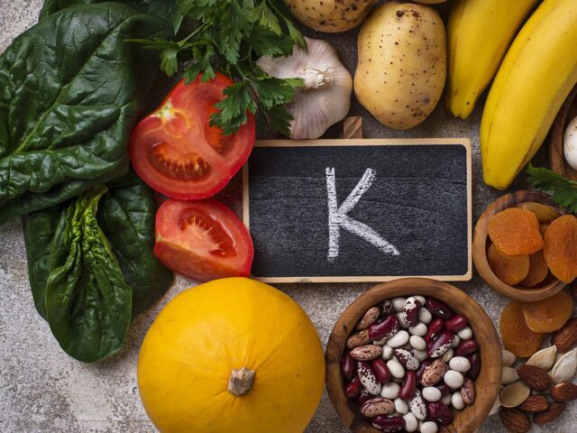 świeży koszyk bananów, awokado, ziemniaków i szpinaku na kuchennym stole